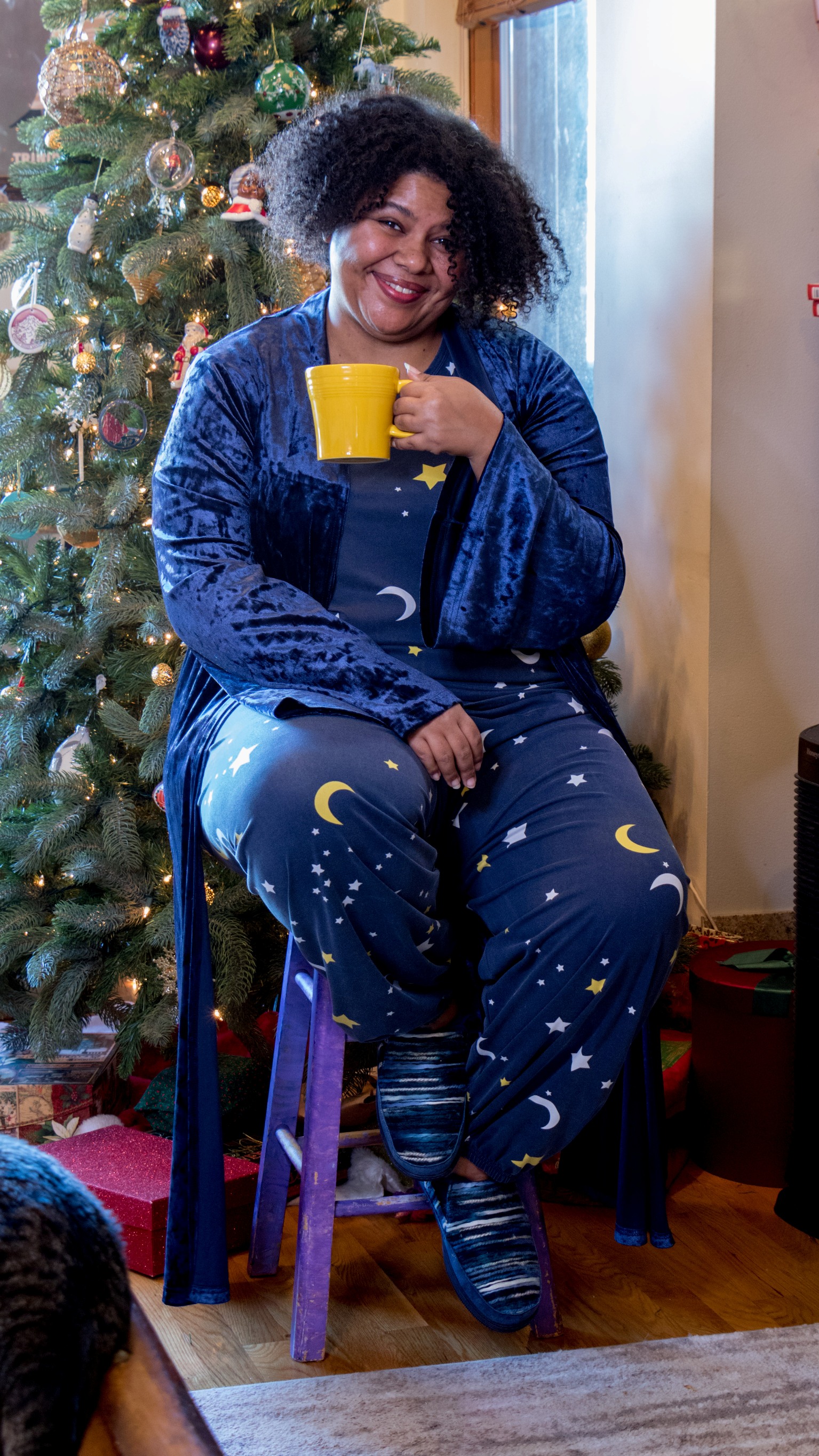 Afrobella in moon and stars pajamas, relaxing by the Christmas tree with a cup of tea. Happy holidays!